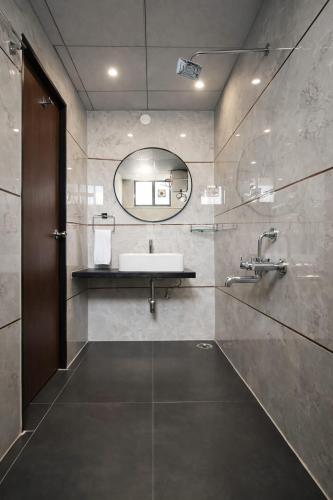 a bathroom with a sink and a mirror at Orin Suites Gachibowli in Hyderabad