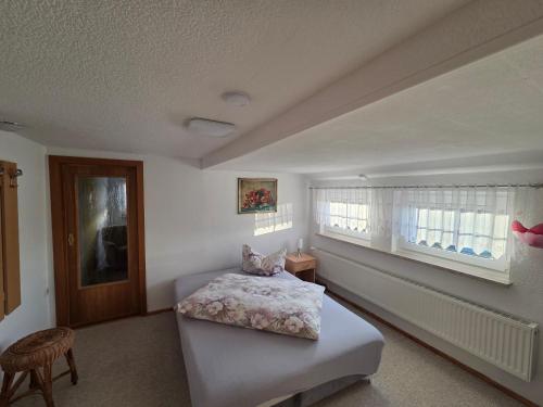 a bedroom with a bed and a window at Ferienhaus Bringfriede in Muldenhammer