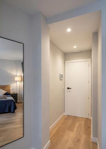 a bedroom with a door and a mirror at Apartamento exclusivo Muralla de Lugo 1.1 in Lugo