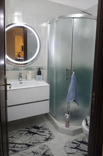 ein Badezimmer mit Dusche, Waschbecken und Spiegel in der Unterkunft Confort Flat in Salé