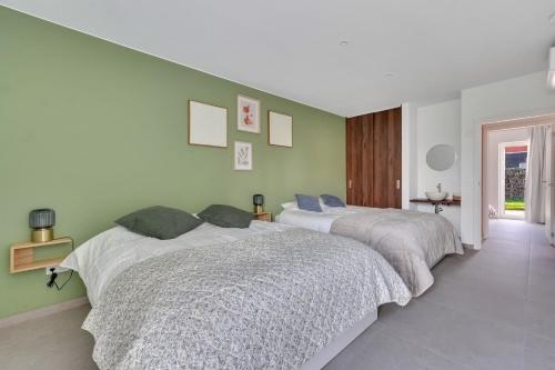 two beds in a bedroom with green walls at 't Vennehuys - vakantiehuis nabij Bokrijk in Genk
