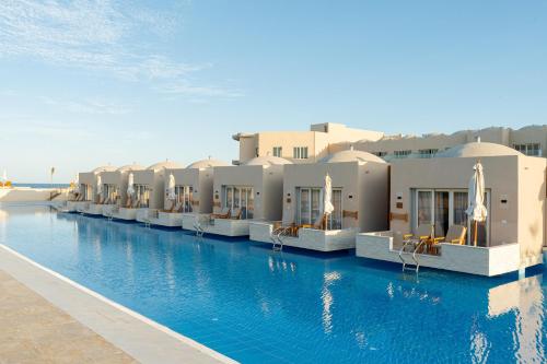 a hotel swimming pool in front of some buildings at Diamond Beach By Pearl Resort in Quseir