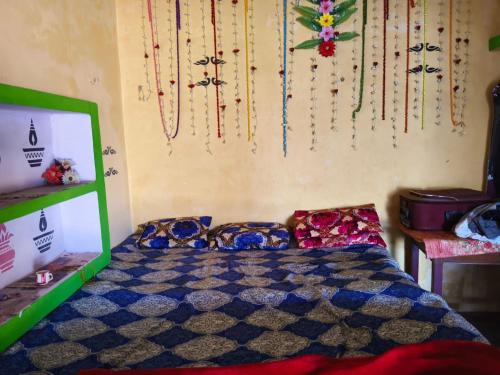 a bedroom with a bed and a wall with decorations at Balendra Kumar in Tarahti