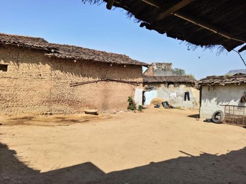 a dirt courtyard in a village with buildings at Balendra Kumar in Tarahti