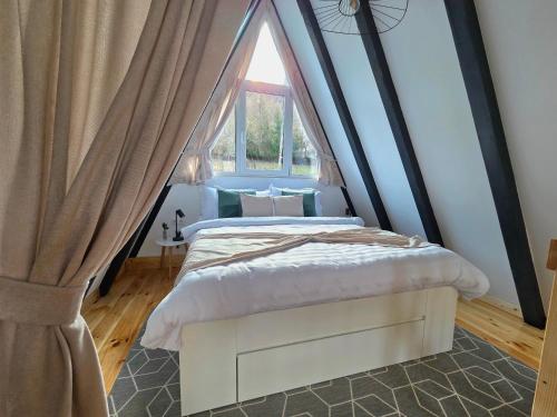 a bedroom with a canopy bed with a window at REIA A-frame in Gura Râului