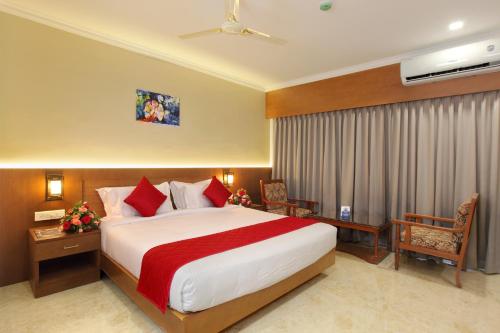 a hotel room with a large bed and a desk at Hotel Indraprastha Kozhencherry in Kozhancheri