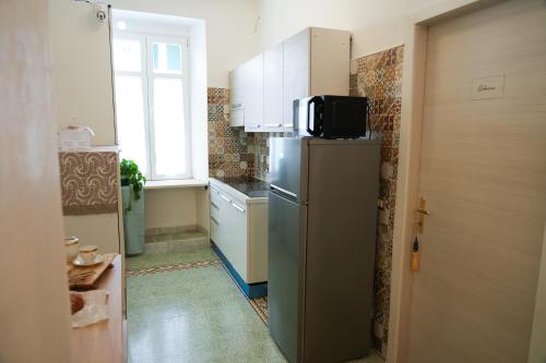 a small kitchen with a refrigerator and a window at La casa in centro in Salerno