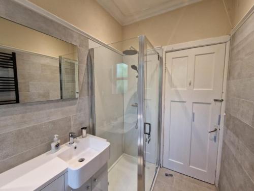 a bathroom with a shower and a sink and a shower stall at Airlie Gardens in Brodick