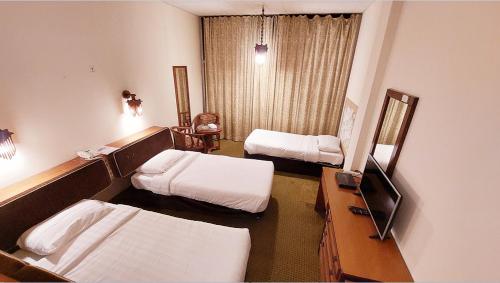 a hospital room with two beds and a mirror at OrientalPalace Hotel in Manama