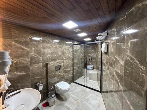 a bathroom with a shower and a toilet and a sink at Nisyan Konağı 1921 in Şahinbey