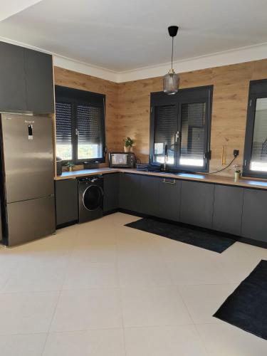 a kitchen with a stainless steel refrigerator and windows at Villa Lila in Cherchell