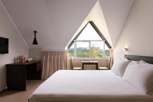 a bedroom with a large bed and a window at Oak Ray Misty Hills in Nuwara Eliya