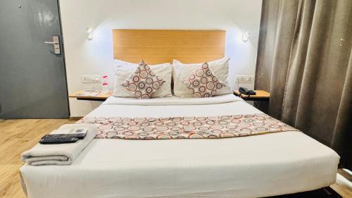 a bedroom with a large bed with a remote control at Hotel CINCO PRIME -PREMIUM ROOMS in Secunderabad