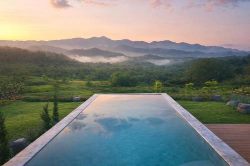 a swimming pool with a view of the mountains at Solitude Villas in Ban Chang Talut
