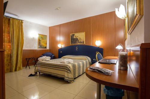 a bedroom with a bed and a desk and a table at Hotel San Luca in Battipaglia