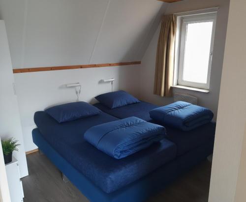 a bedroom with two blue pillows on a bed at De Eekhoorn in Gramsbergen