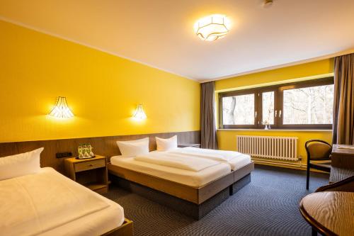 a hotel room with two beds and a window at Hotel Grunewald in Berlin