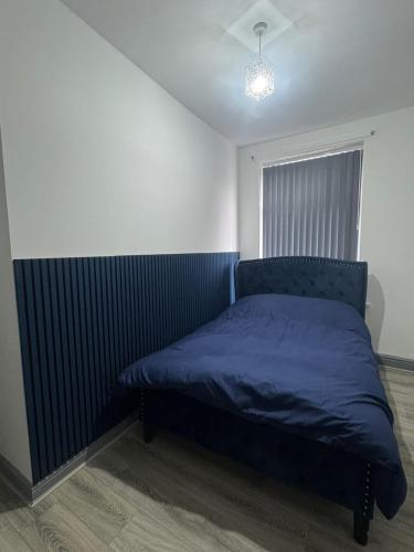 a bedroom with a bed with a blue blanket at Modern Apartment Bradford City Centre Self Check In in Bradford