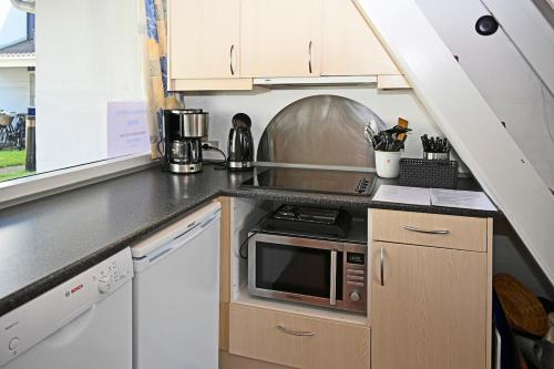 a kitchen with a counter top with a microwave at Marielyst Nørrevang-solrig-sydvendt-centralvarme in Bøtø By
