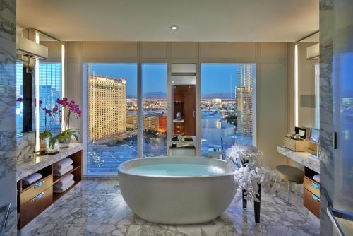 a bathroom with a tub and a view of a city at Waldorf Astoria Las Vegas in Las Vegas