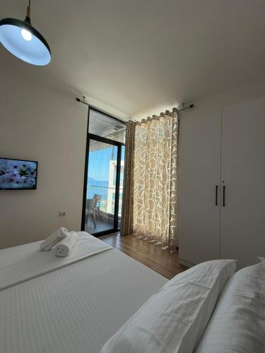 a bedroom with two beds and a large window at Sunny Hill Residence in Vlorë