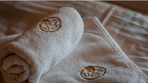 a roll of white towel sitting on a bed at Hotel LOKIS in Niedzica Zamek