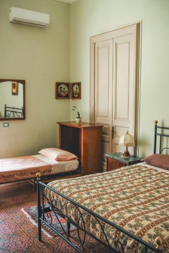 a bedroom with two beds and a mirror at Casa Verdi - House of Travelers in Catania