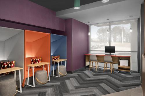 a room with purple walls and a desk with chairs at Tru By Hilton Stockbridge in Stockbridge