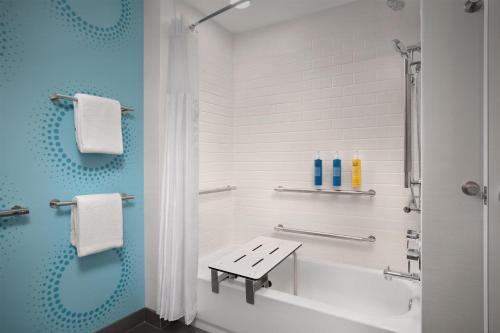 a bathroom with a white tub and a sink at Tru By Hilton Huntsville Research Park Area in Huntsville