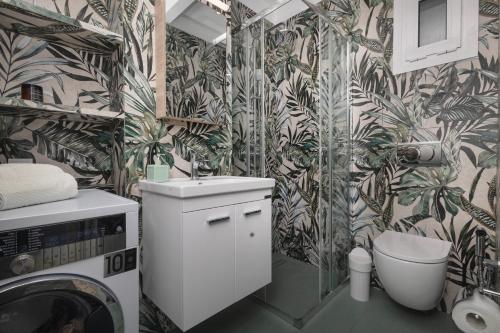 a bathroom with a toilet and a washing machine at Casa de Colores en Corfu! in Corfu