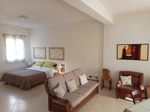 a bedroom with a bed and a couch at Il rifugio dello scultore in Niscemi