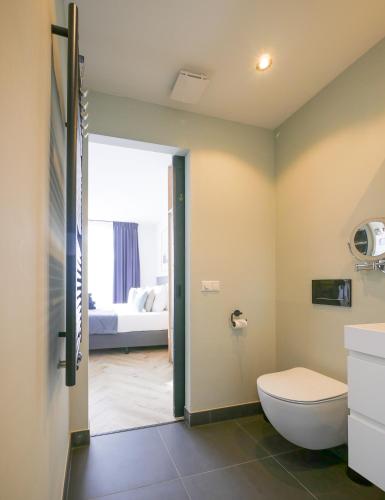 a bathroom with a toilet and a bedroom at Hosted by Wendy Prins Willem 3 in Scheveningen