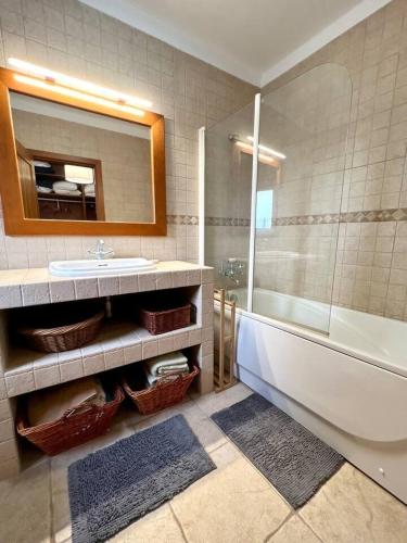 a bathroom with a sink and a tub and a mirror at Villa Mar & Surf • Piscina privada in Atouguia da Baleia