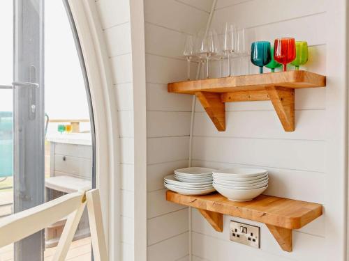 a small kitchen with wooden shelves and plates at 2 Bed in Tain oc-81339 in Nigg