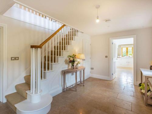a staircase in a home with a table and flowers at 4 Bed in Wrexham oc-87675 in Chirk