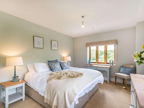 a bedroom with a bed and a desk and a window at 4 Bed in Wrexham oc-87675 in Chirk