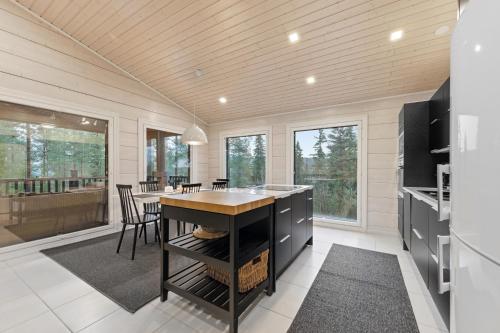 a kitchen with a table and chairs in a house at Villa Länsihuippu Incl WiFi, Pool table, AC, Jacuzzi for extra fee in Himos