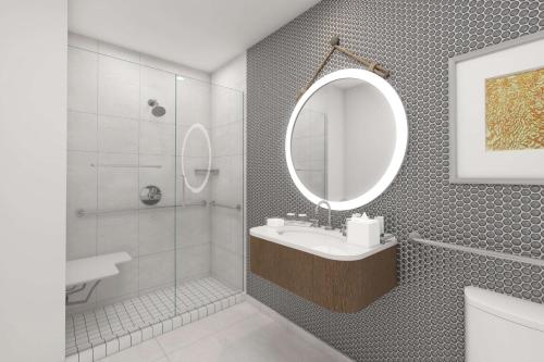 a bathroom with a sink and a mirror and a shower at The Reach Key West, Curio Collection by Hilton in Key West