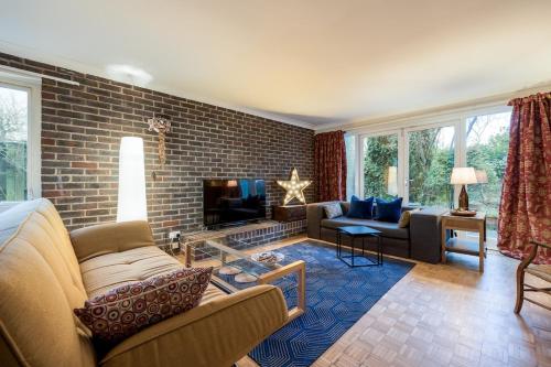 a living room with a brick wall at Large 5-Bed Home Next to JR Hospital Parking in Oxford