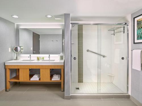 a bathroom with a shower and a sink at DoubleTree by Hilton Edmonton Downtown in Edmonton