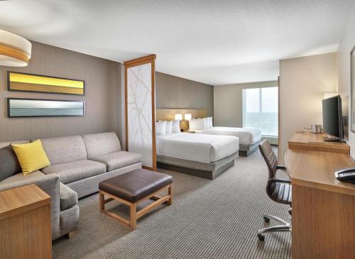 a hotel room with a bed and a living room at DoubleTree by Hilton Edmonton Downtown in Edmonton