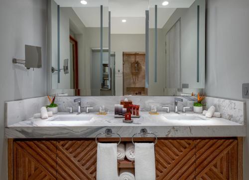 a bathroom with two sinks and a large mirror at Conrad Punta de Mita in Punta Mita