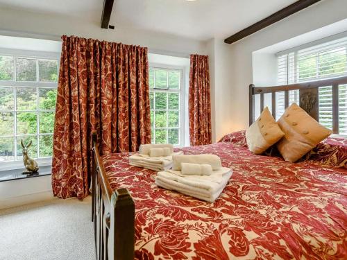 a bedroom with a large red bed with pillows at 2 Bed in Llandysul oc-85444 in Felindre
