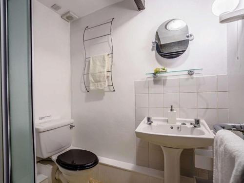 a white bathroom with a toilet and a sink at 2 Bed in Llandysul oc-79199 in Felindre