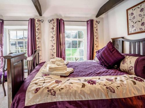 a bedroom with a bed with purple sheets and windows at 2 Bed in Llandysul oc-79199 in Felindre