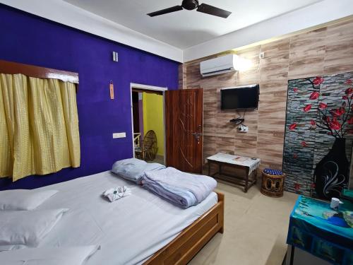 a bedroom with a large bed with a purple wall at Orchid Resort in Lataguri