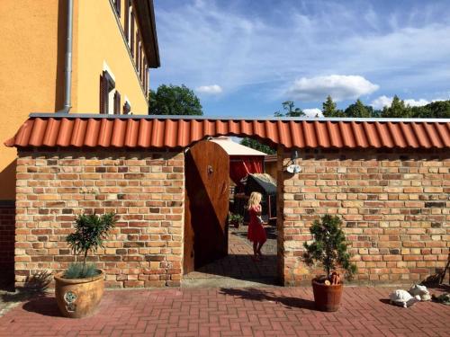 a woman is walking through a brick wall at Pension Max in Senftenberg