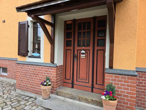 a front door of a house with two potted plants at Pension Max in Senftenberg