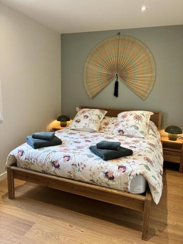 a bed with two pillows and an umbrella on it at Gîte Le 10 in Neuville-du-Poitou
