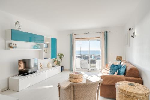 a living room with a couch and a table at Caparica Ocean View in Costa da Caparica